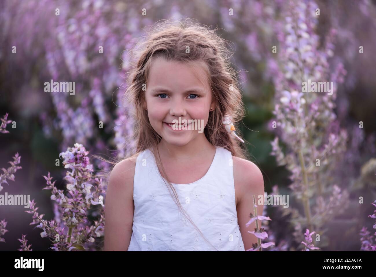 Close-up Portraits of a little girl with long flowing hair in blooming ...
