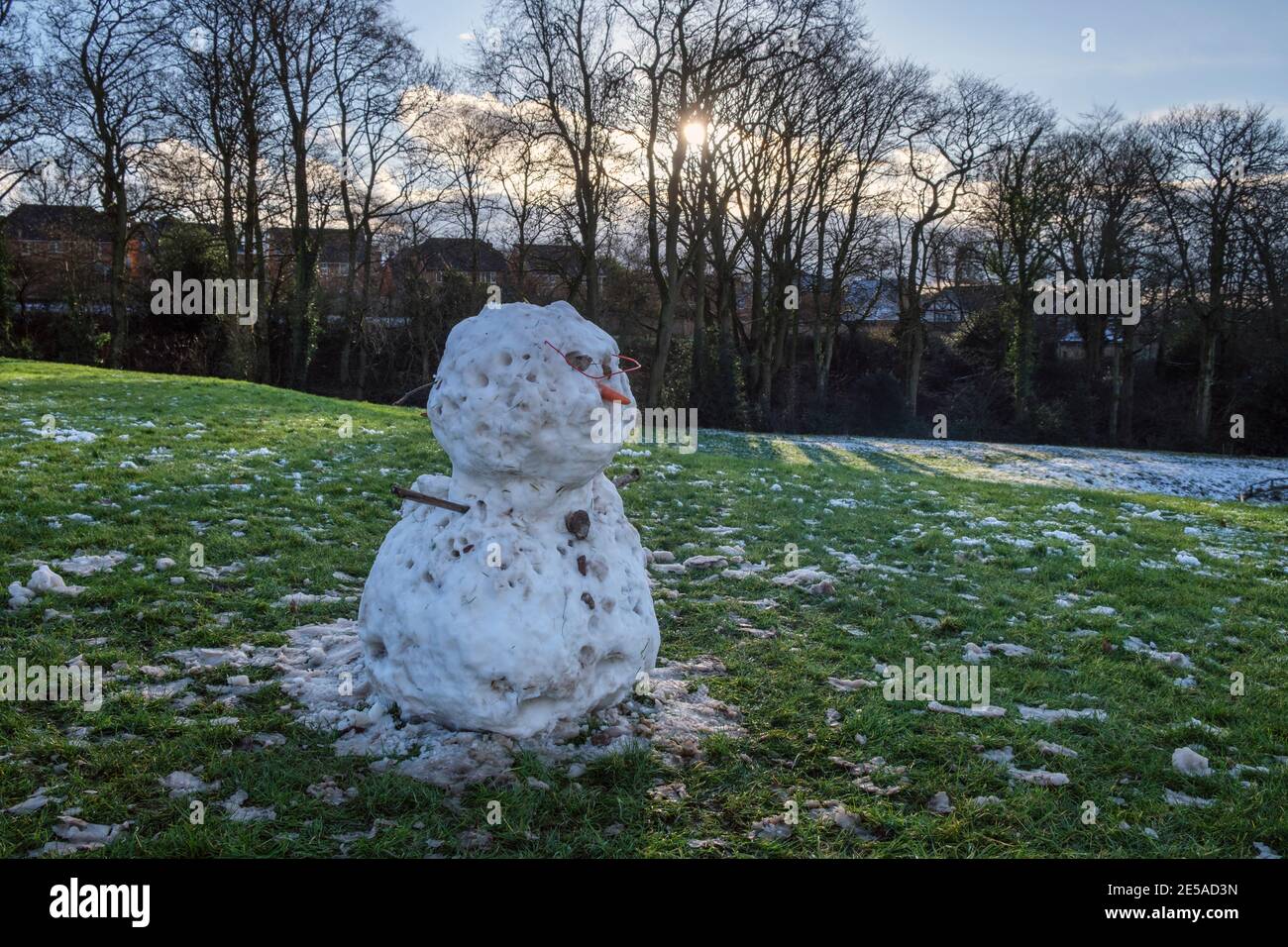 A snowman melting in the sunshine, Ashbourne, Derbyshire Stock Photo