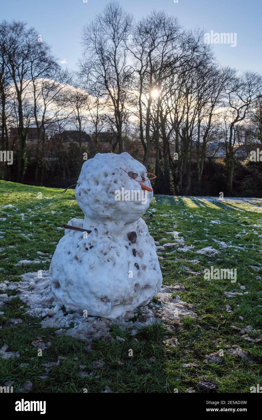 A snowman melting in the sunshine, Ashbourne, Derbyshire Stock Photo