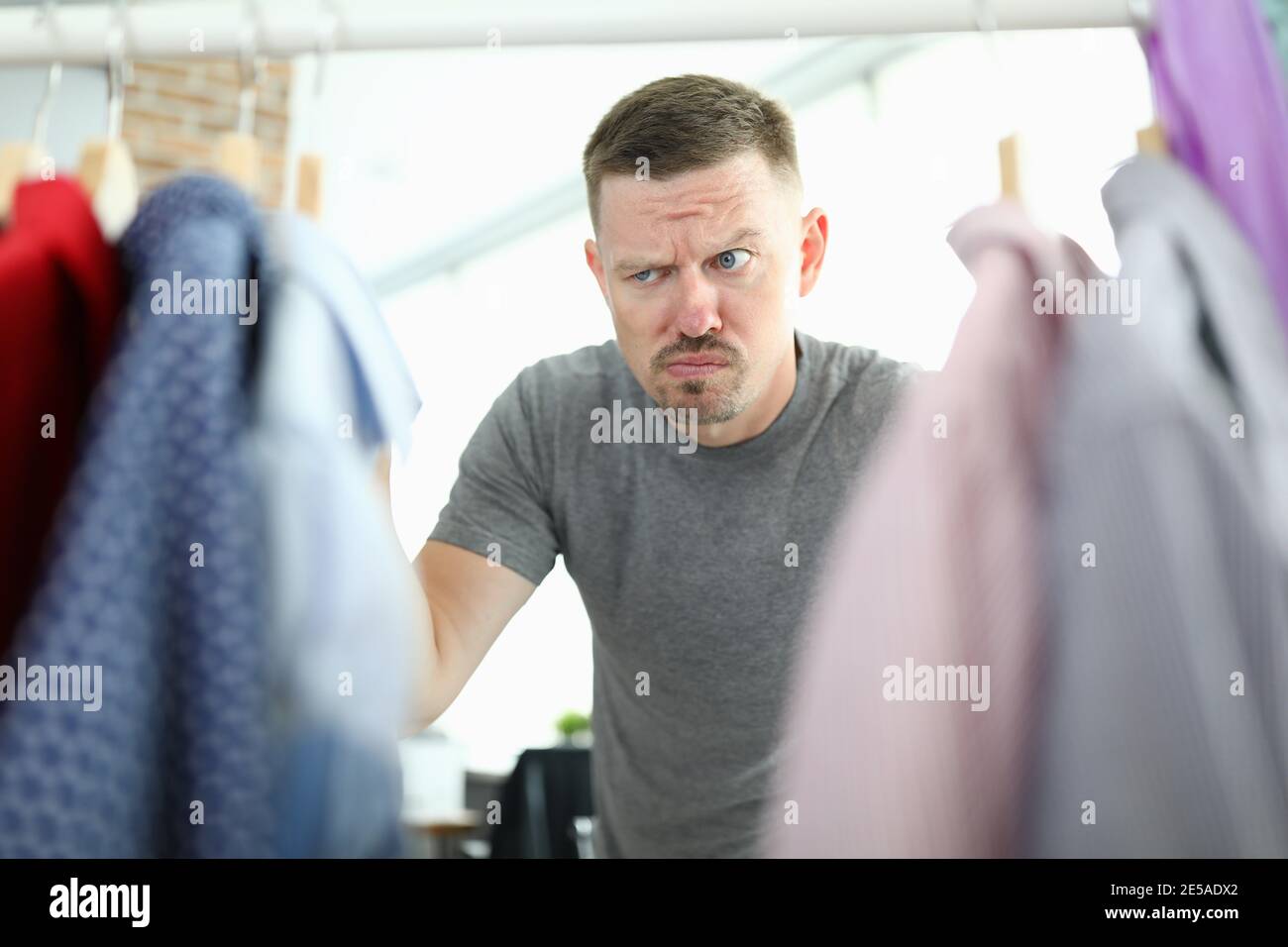 Young man choosing shirt in wardrobe closeup Stock Photo - Alamy