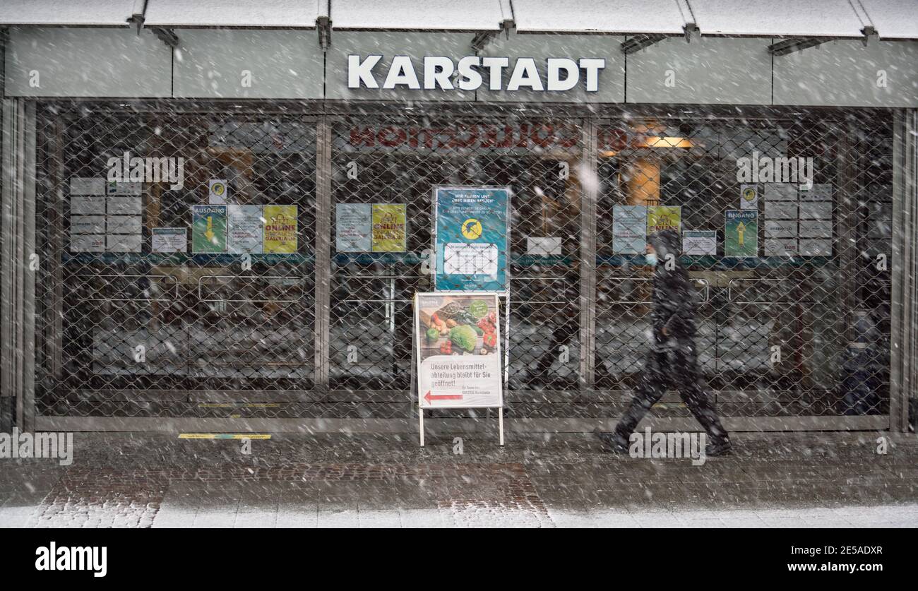 Bad Homburg, Germany. 27th Jan, 2021. A man walks past the closed main entrance of the Karstadt store in Bad Homburg in a light snowstorm. The German government is negotiating with the ailing department store group Galeria Karstadt Kaufhof about state aid. A decision could be made on Wednesday (27.01.2021) at a meeting of the Economic Stabilization Fund Committee. Credit: Frank Rumpenhorst/dpa/Alamy Live News Stock Photo