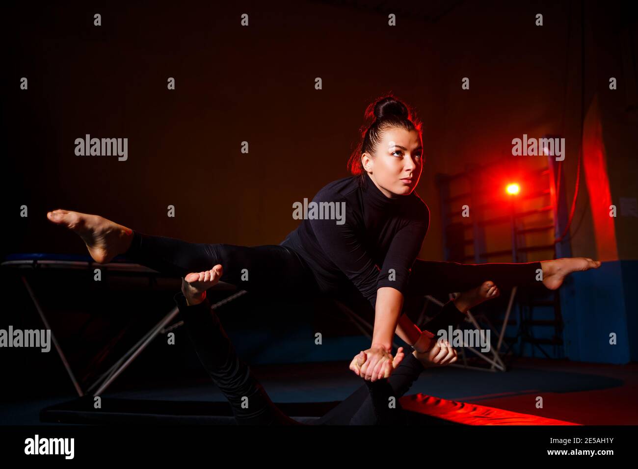 Young woman and man gymnasts do acrobatic exercises in the gym. Sports