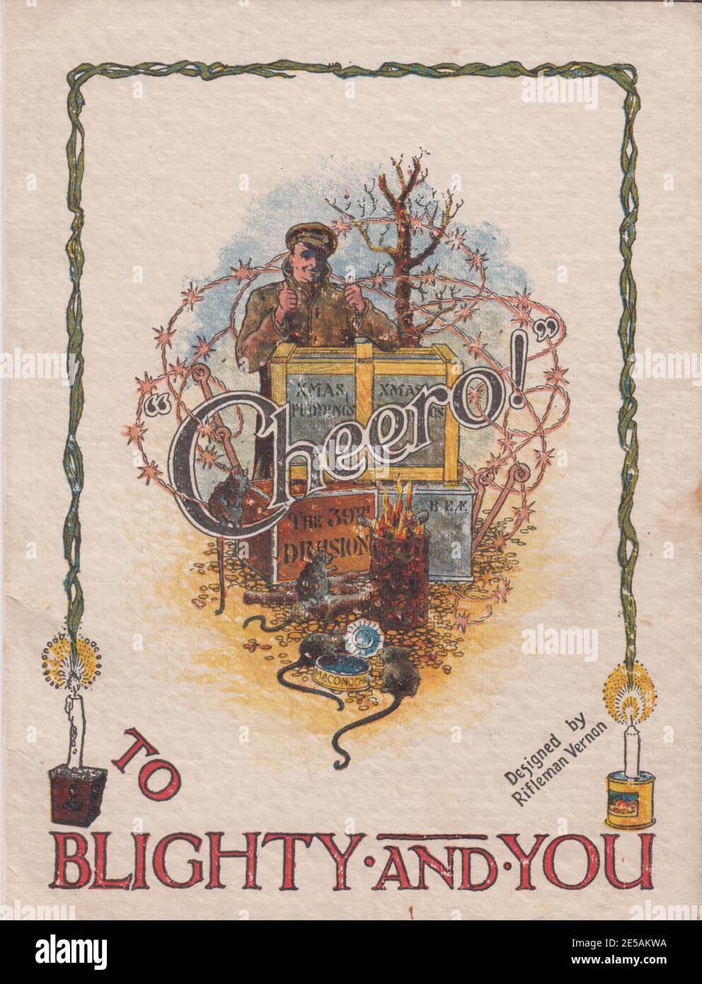 First World War Christmas card addressed to Blighty and You, from the 39th Division of the British Expeditionary Force, 1917. The colour illustration shows a smiling soldier with both thumbs up behind cases of Christmas puddings, rats are eating from a tin and standing by a fire in the foreground and there is barbed wire in the background Stock Photo