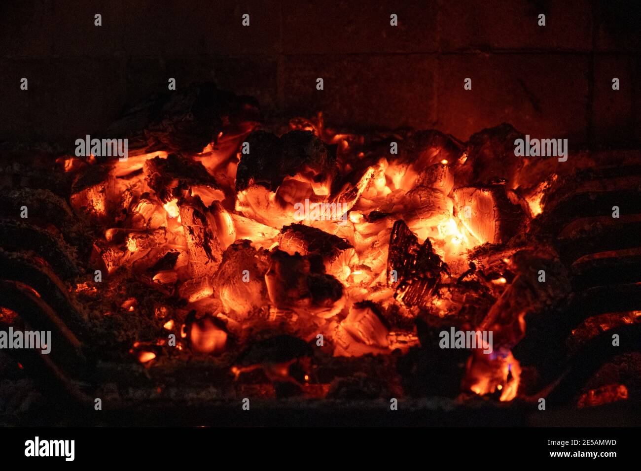Burning hot wood coal on the fire pit in the darkness. Alive warm and