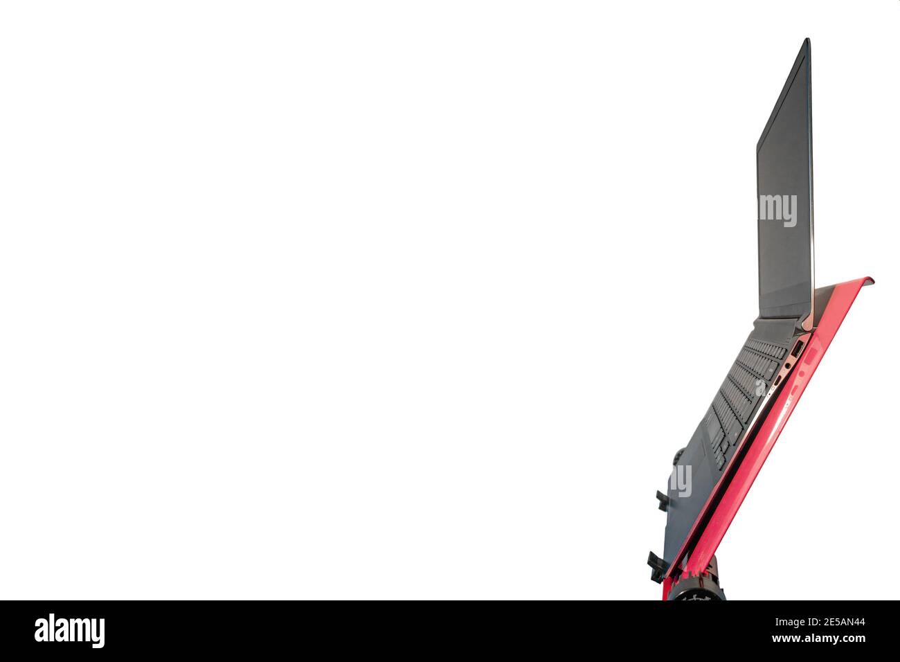 Open slim and modern laptop computer at a red stand isolated at white ...