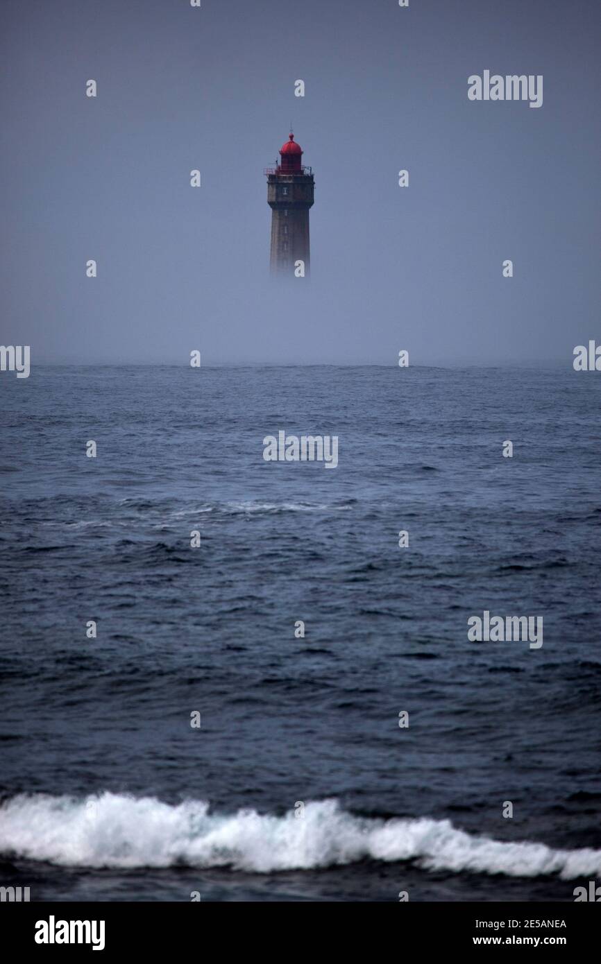 The dramatic La Jument lighthouse, shrounded in summer fog, off the coast of the Ile d'Ouessant, Brittany. The iconic 47-metre high lighthouse was bui Stock Photo