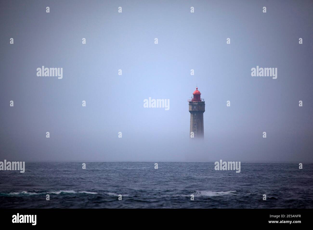The dramatic La Jument lighthouse, shrounded in summer fog, off the coast of the Ile d'Ouessant, Brittany. The iconic 47-metre high lighthouse was bui Stock Photo