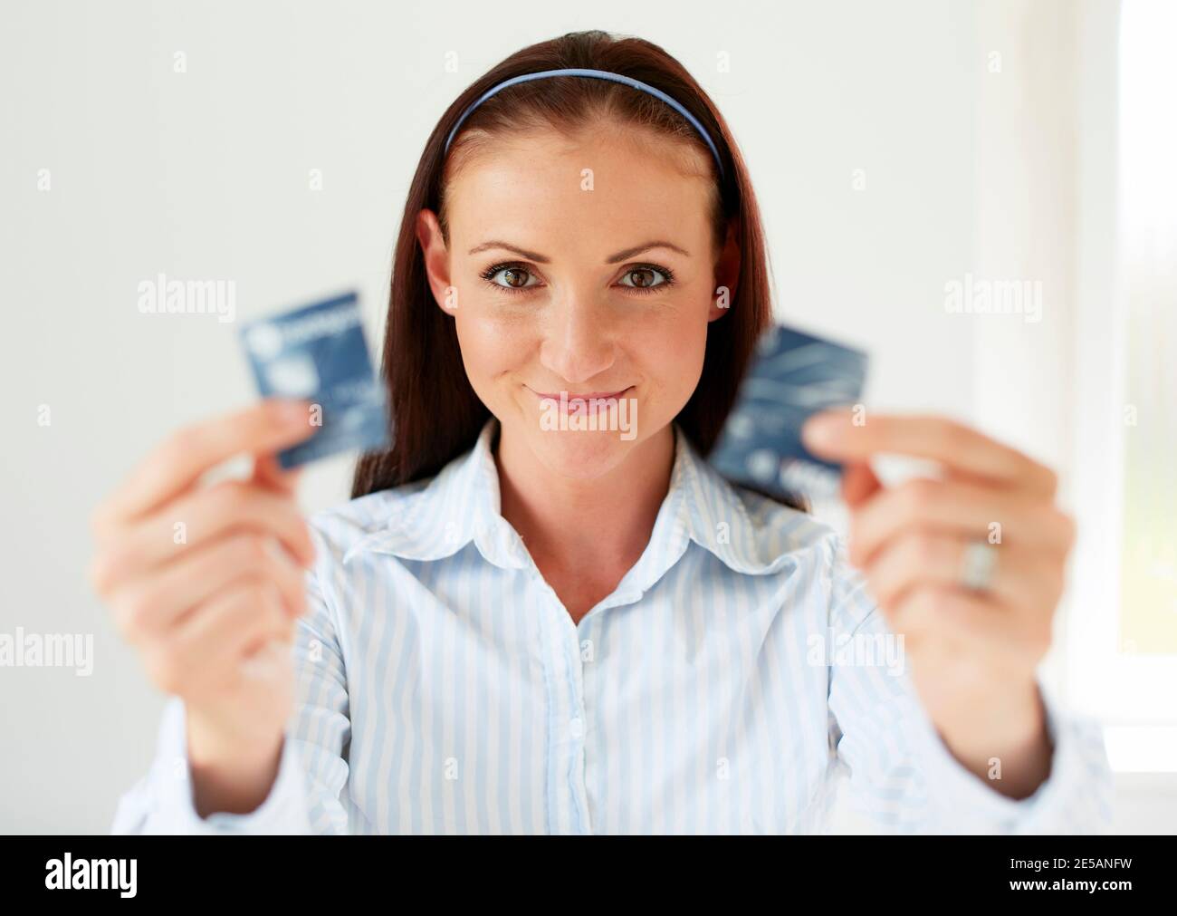 Woman holding credit card cut in half Stock Photo