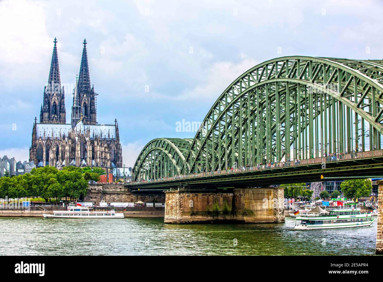 Die grün gestrichene Deutzer Brücke überspannt den Rhein vom Kölner Dom zu den rechtsrheinischen Stadtteilen. Die Brücke ist eine Eisenbahnbrücke, kan Stock Photo