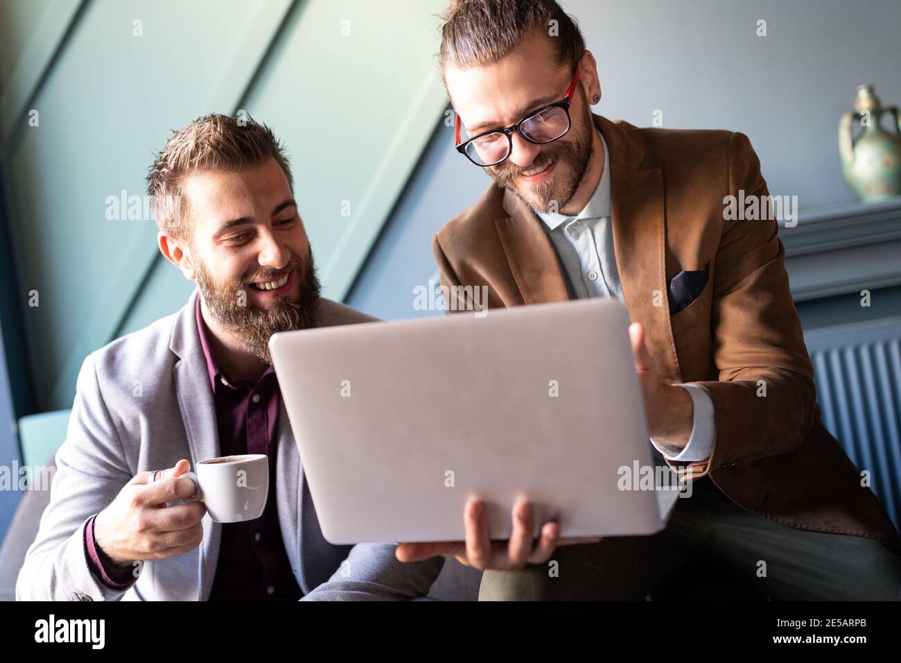 Sharing fresh ideas. Group of young business people in smart casual wear talking and smiling Stock Photo