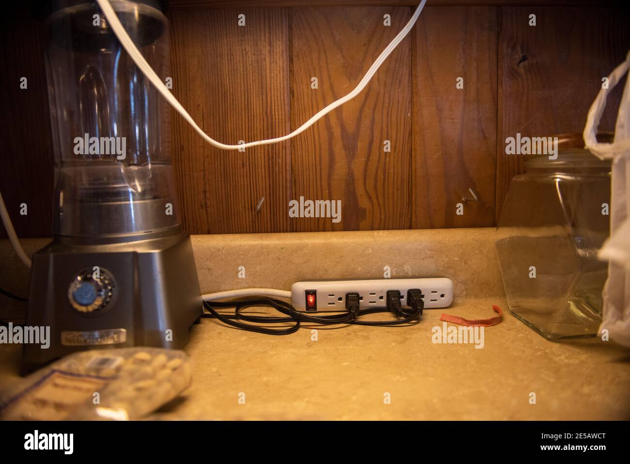 A surge protector with many cords plugged in. Stock Photo