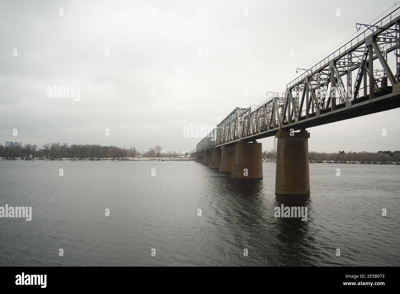 Railway bridge over Dnipro river in Kyiv. Industrial steel bridge across the river. Stock Photo