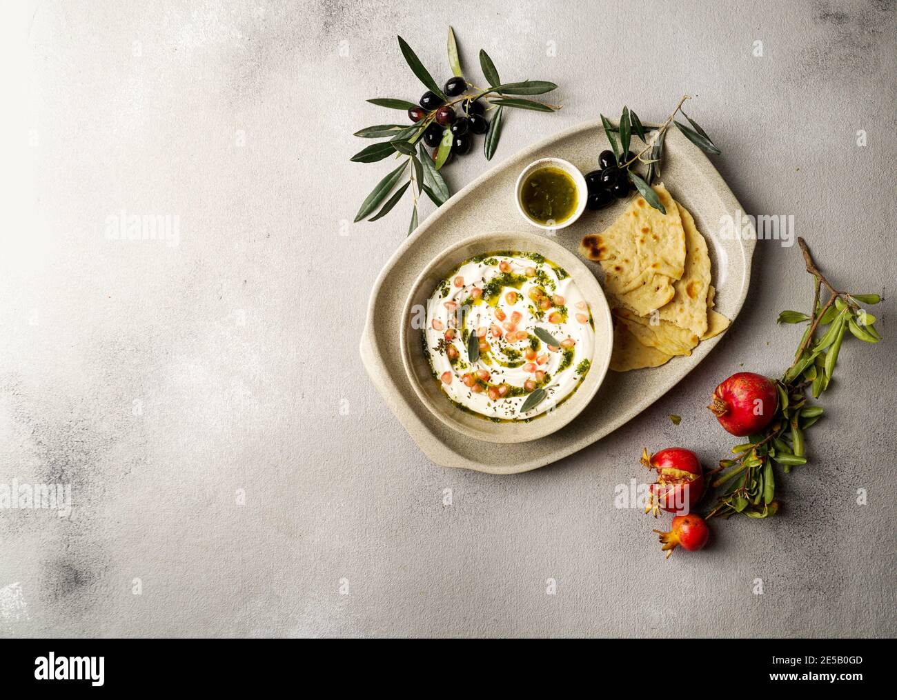 iranian or arabian dish, yogurt labneh goats milk dip with taftan bread and pomegranate Stock