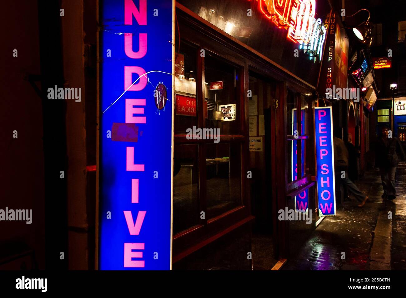 Red light district in Soho London at night with illuminated signage advertising nude live show and peep show Stock Photo