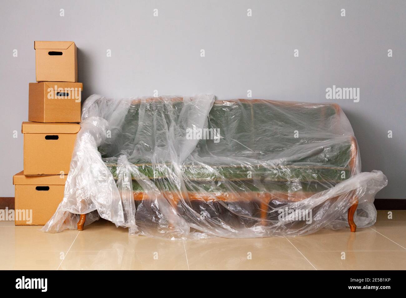 Packed household stuff in boxes and packed sofa for moving Stock Photo