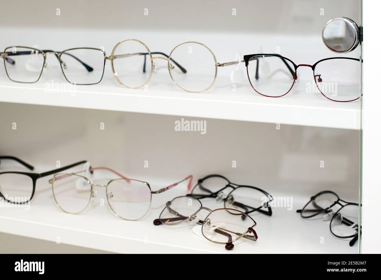 Eyeglasses in optical store, fashion, different glasses on white shelf in  shopping mall. Selective focus Stock Photo - Alamy