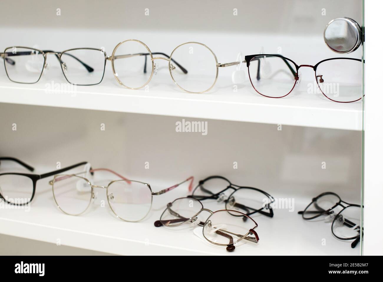 Eyeglasses in optical store, fashion, different glasses on white shelf