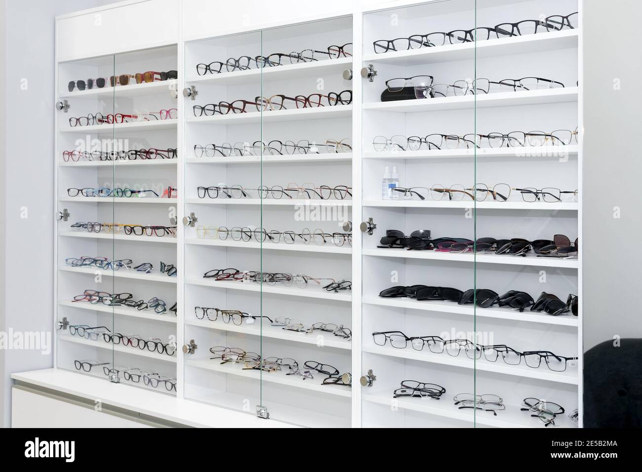 Eyeglasses in optical store, fashion, different glasses on white shelf in shopping mall