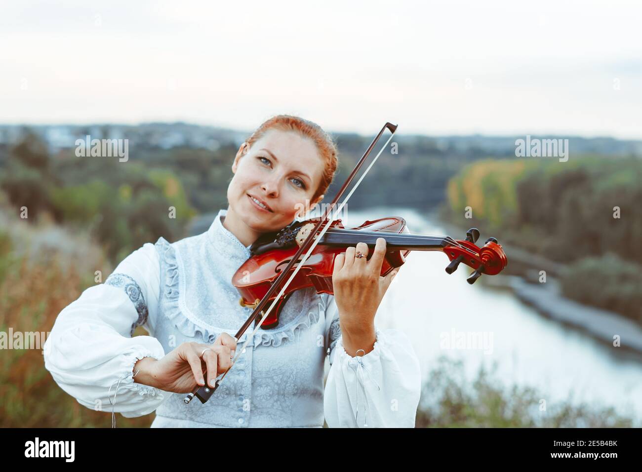 beautiful girl playing violin in white dress in forest Stock Photo - Alamy