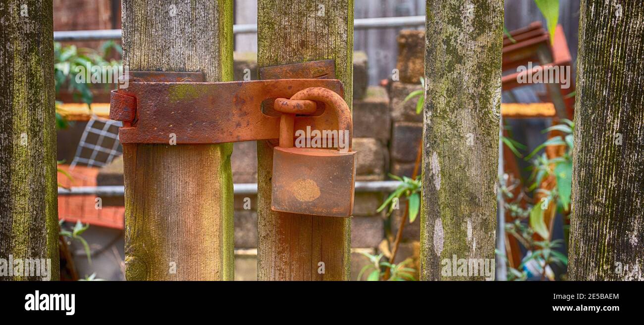 Rusty padlock on wooden gate Stock Photo