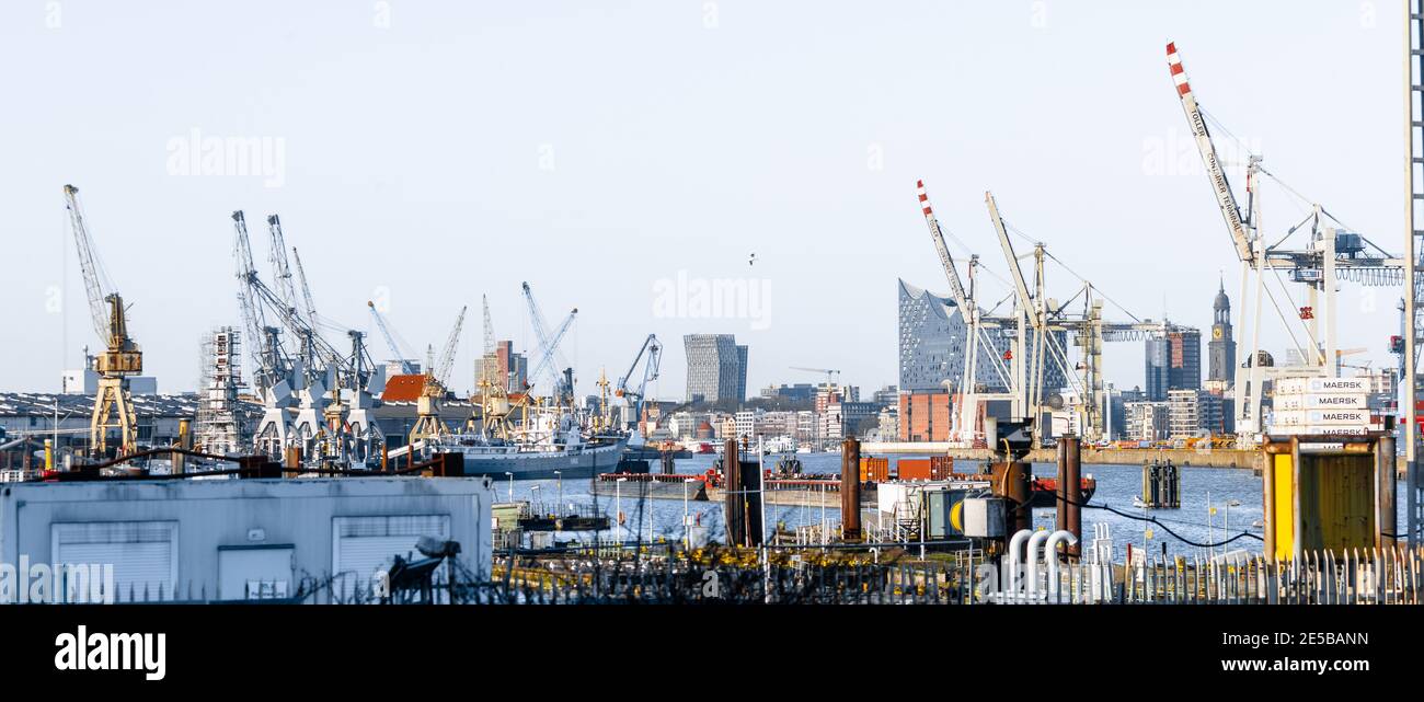 25 December 2020, Hamburg: Historic cranes of the Hamburg Harbour Museum (l-r), the Dancing Towers of the Reeperbahn, the Elbphilharmonie behind container cranes of the Hansa Harbour, the Kehrwiederspitze and the tower of the main church St. Michaelis form the skyline of the Hanseatic City of Hamburg. Photo: Markus Scholz/dpa Stock Photo