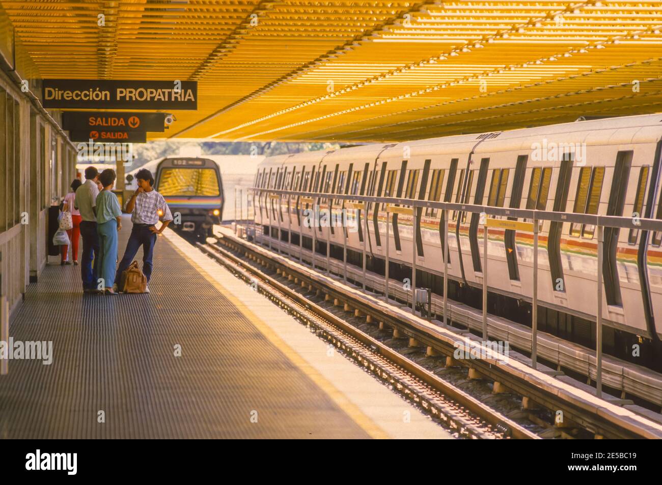 CARACAS, VENEZUELA, 1988 - Metro train and passengers waiting on platform. Stock Photo