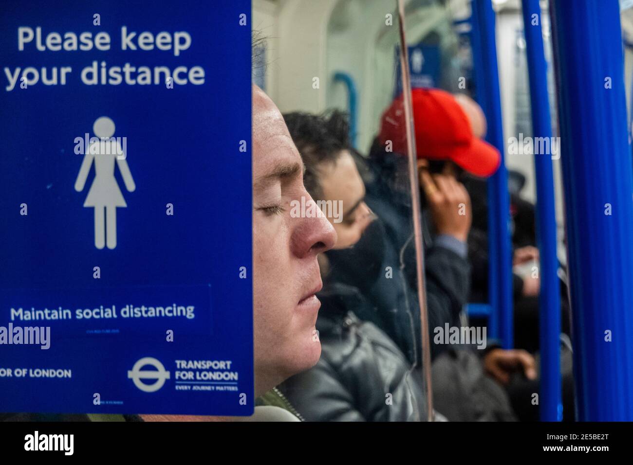 London, UK. 27th Jan, 2021. Despite passing 100,000 deaths there are still people not wearing masks, although possibly they have a valid reason! The underground is still fairly busy despite the new national Lockdown, Stay at Home, instructions. Most travellers wear masks as they are already mandatory. Credit: Guy Bell/Alamy Live News Stock Photo