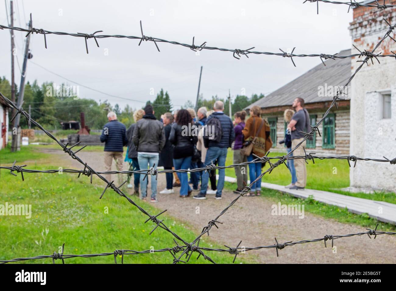 Barbwire and tourists visiting the Gulag Perm-36 / ITK-6 / Gulag Museum, Soviet forced labour camp near the village Kuchino, Perm Krai, Russia Stock Photo