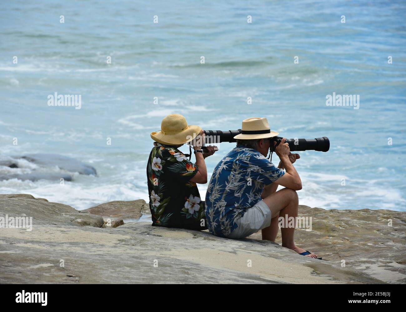 Senior couple photographers with their cameras and lenses taking photos