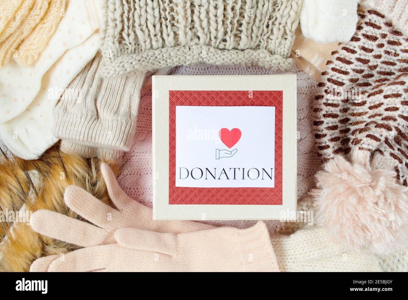 winter flat lay with mittens, hats, winter clothes and donation box on  white knitted background Stock Photo - Alamy