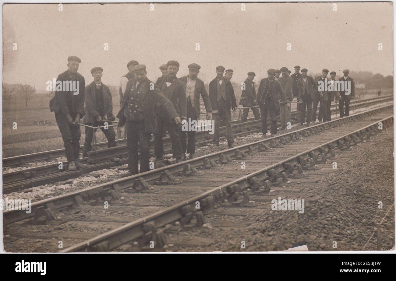 Edwardian platelayers working on the railway tracks, most wearing flat caps Stock Photo