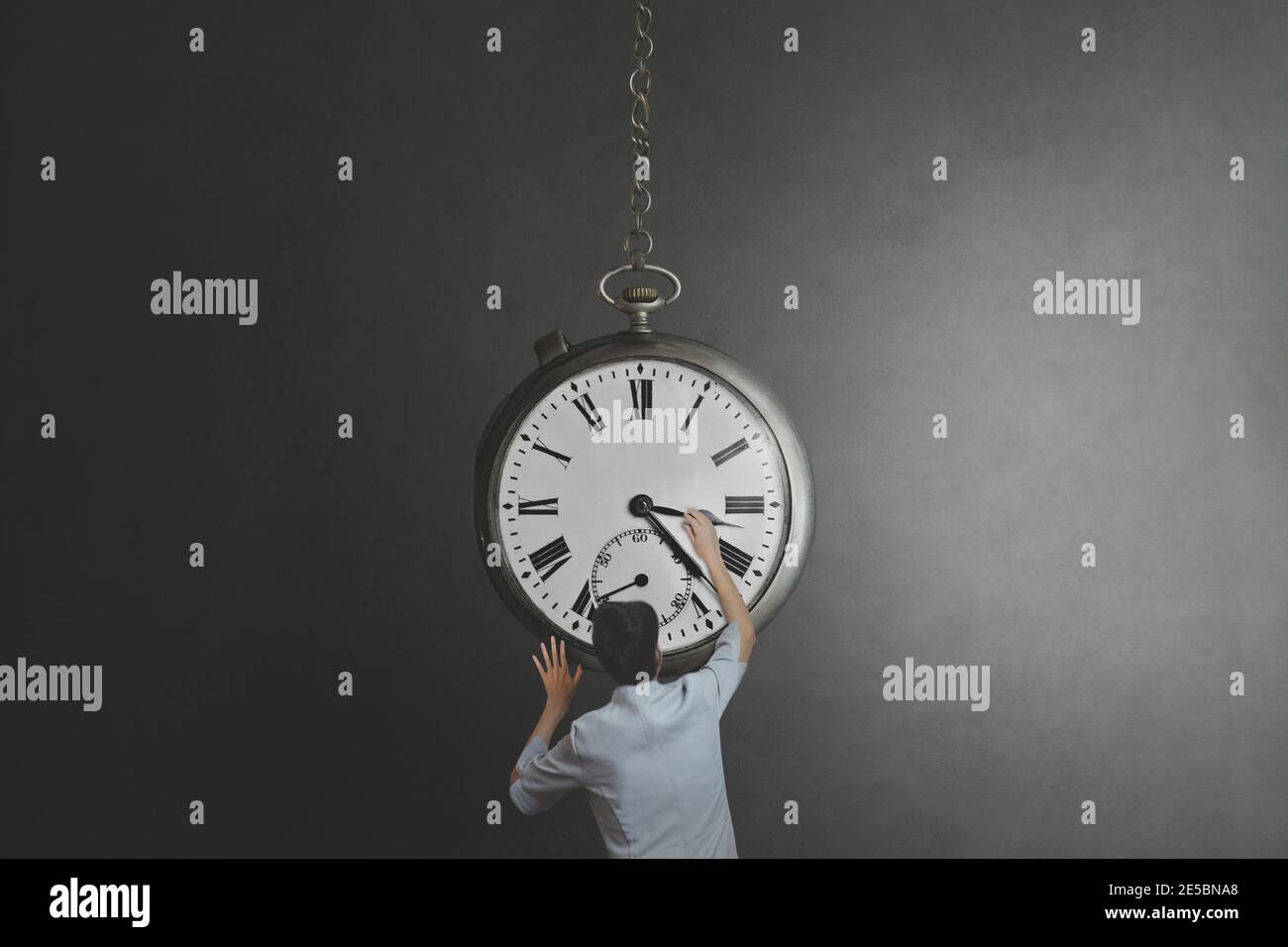 surreal moment of a woman trying to control time Stock Photo