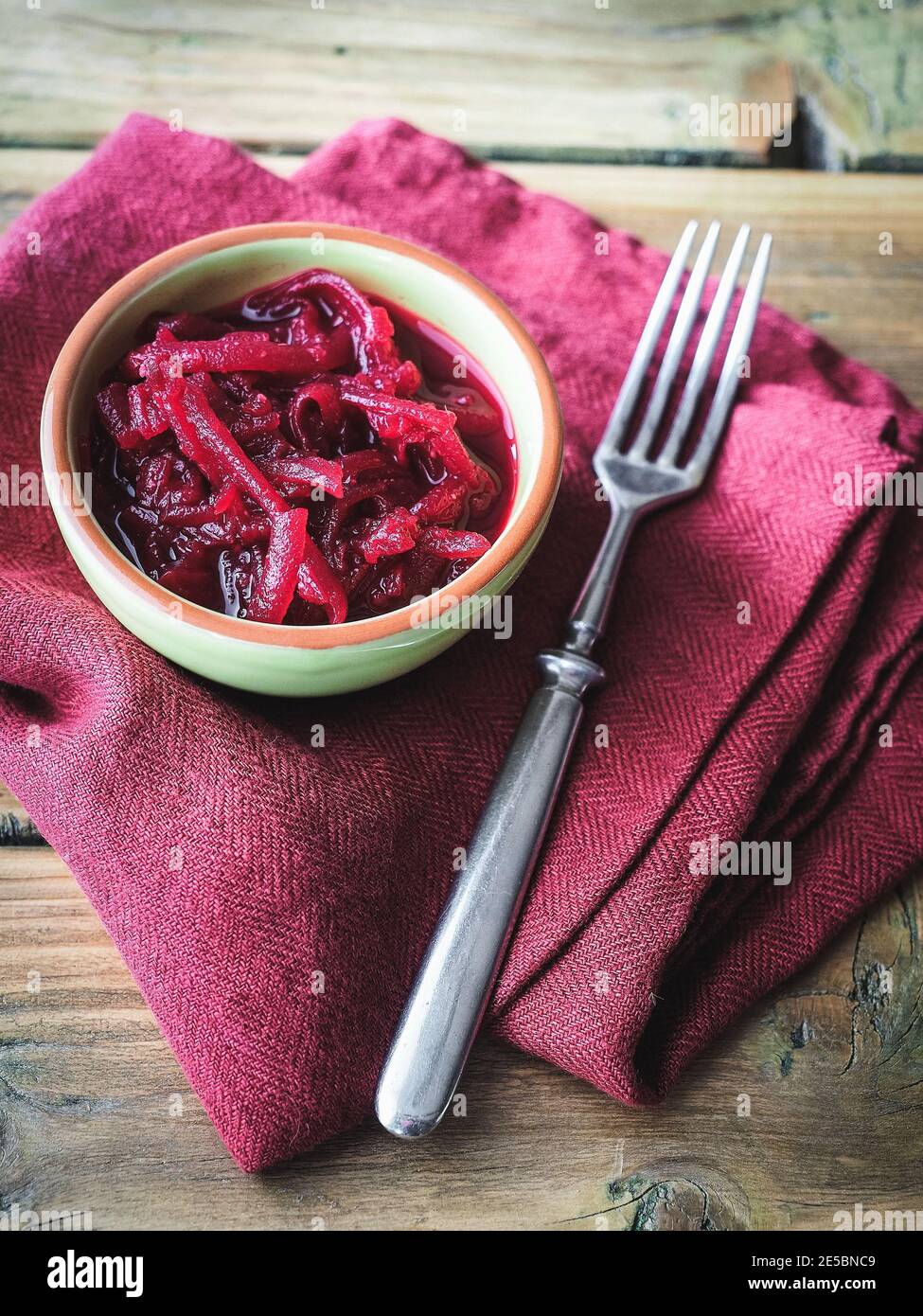 Bowl of sliced beetroot on wooden table. Red linen on background. Copy space.  Stock Photo