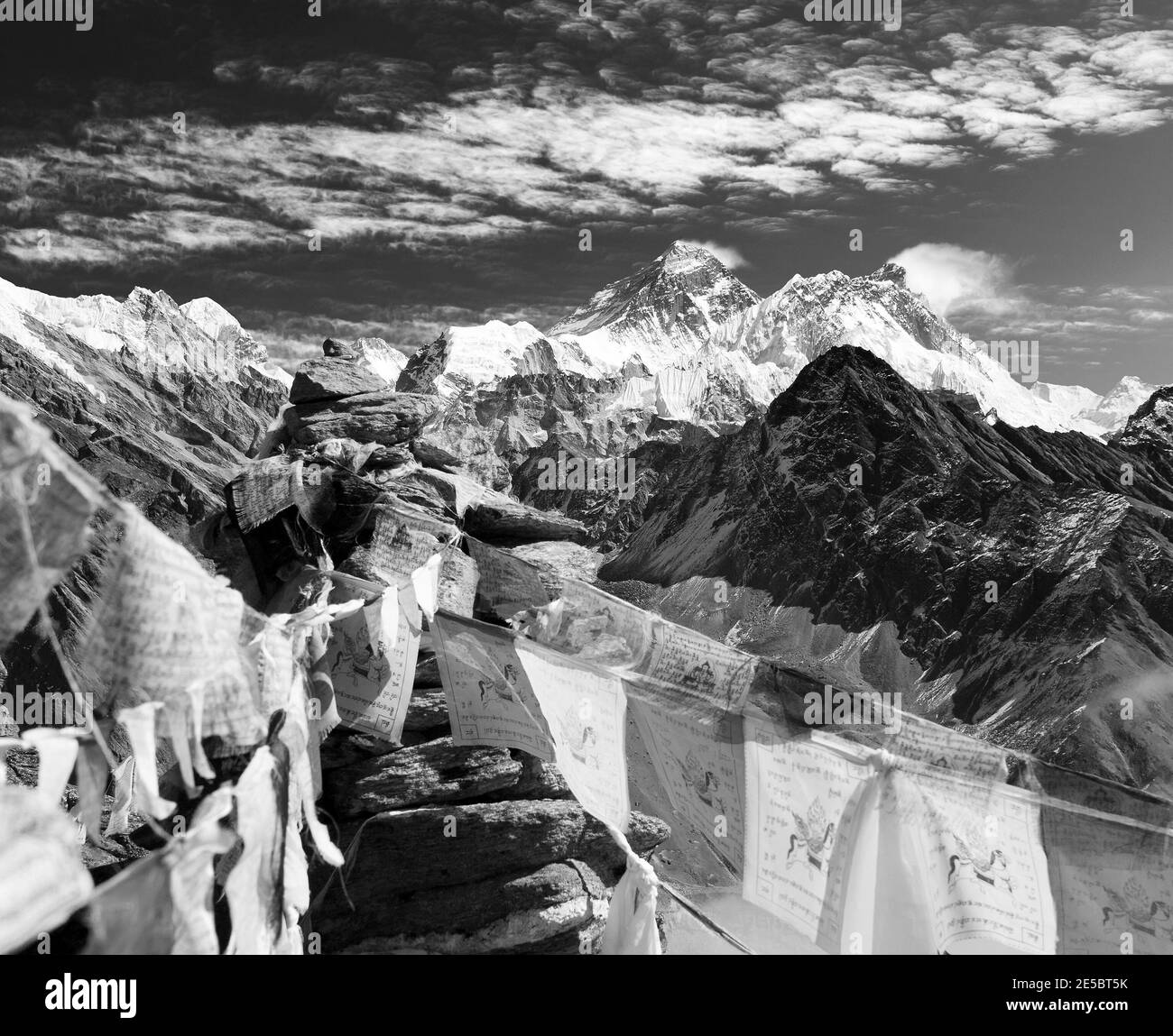 Black and white view of everest from gokyo ri with prayer flags and clouds - Nepal Stock Photo