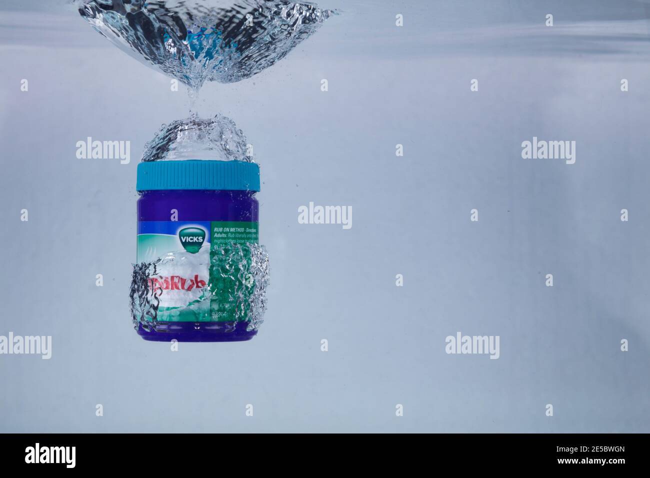 Hi-speed shot of a tin of Vicks Vaporub dropping into water. Ultra hi-speed of 1/5000th of a second. Stock Photo