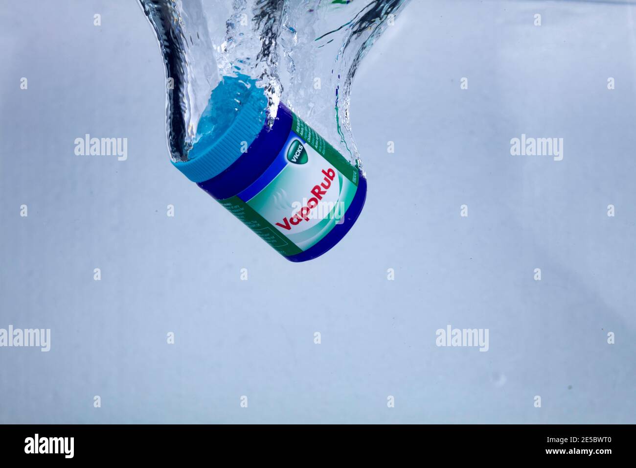 Hi-speed shot of a tin of Vicks Vaporub dropping into water. Ultra hi-speed of 1/5000th of a second. Stock Photo