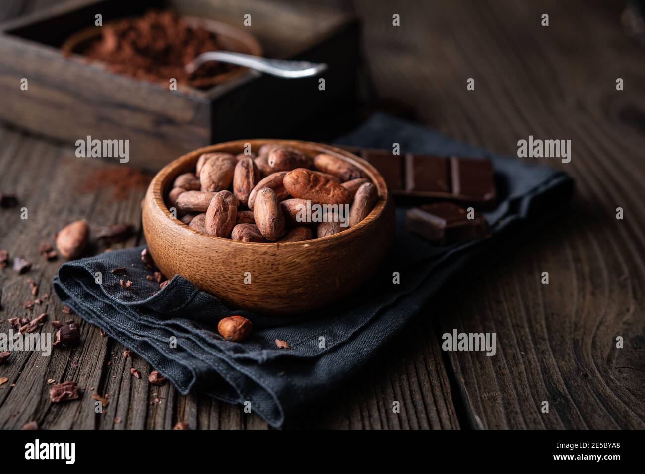 Healthy snack, superfood unroasted cocoa beans in a wooden bowl