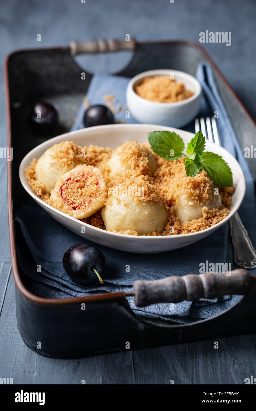 Freshly boiled plum dumplings topped with sweet toasted breadcrumbs in a bowl Stock Photo