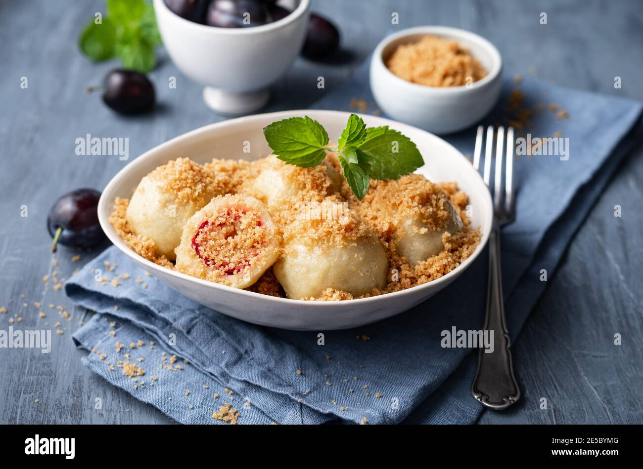 Freshly boiled plum dumplings topped with sweet toasted breadcrumbs in a bowl Stock Photo