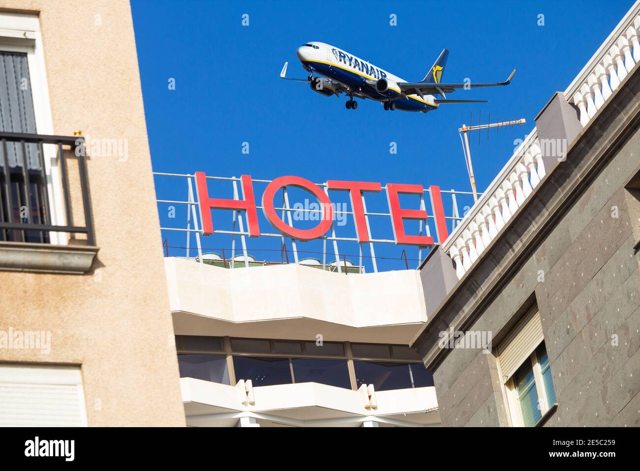Composite image showing Ryanair aircraft flying over hotel. Quarantine hotel, Travel, airline industry, Coronavirus.. Stock Photo