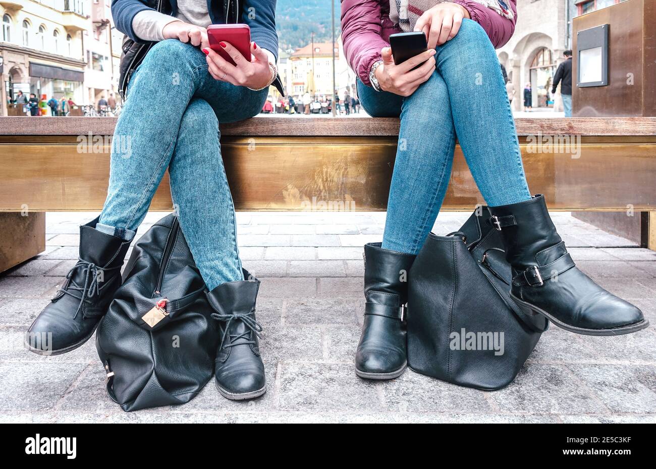 Low section of girlfriends couple sharing content on mobile smart phones - Technology addiction concept with always connected millenials Stock Photo