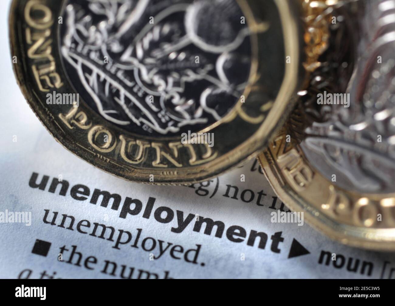 DICTIONARY DEFINITION OF WORD UNEMPLOYMENT WITH ONE POUND COINS RE COVID 19 CORONAVIRUS WORKERS UNEMPLOYED ETC UK Stock Photo