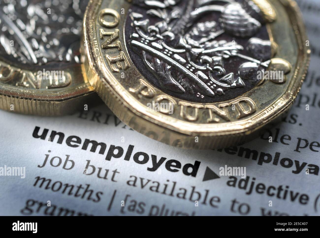 DICTIONARY DEFINITION OF WORD UNEMPLOYED WITH ONE POUND COINS RE COVID 19 CORONAVIRUS WORKERS FURLOUGHED FURLOUGH ETC UK Stock Photo