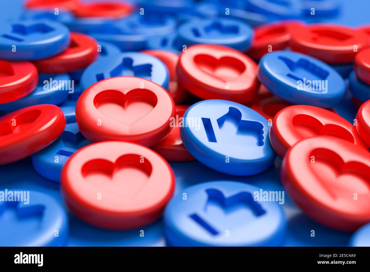 A mix of like buttons with an engraved heart in red and thumbs up in blue on a heap. Blue background. Social Media Concept. Full frame. Stock Photo