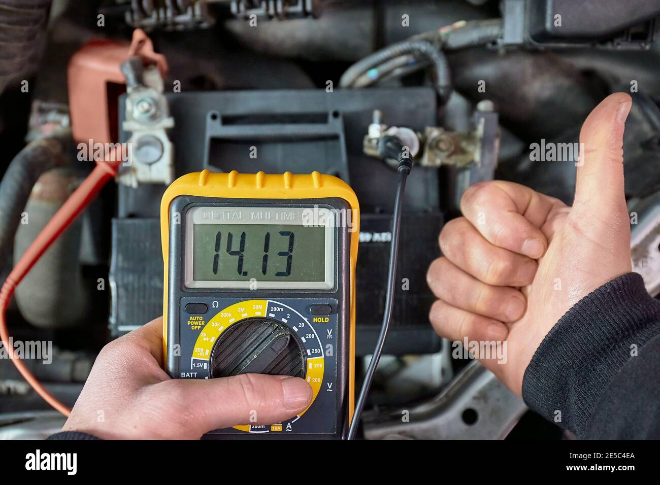 Checking car battery and alternator voltage with running engine Stock Photo  - Alamy