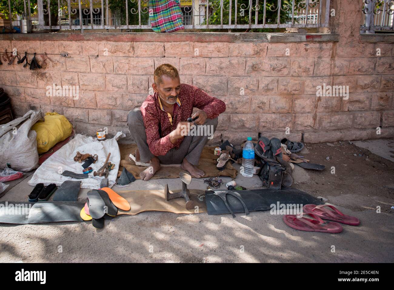 Shoe maker and repair in the streets of Jodhpur city in India Stock