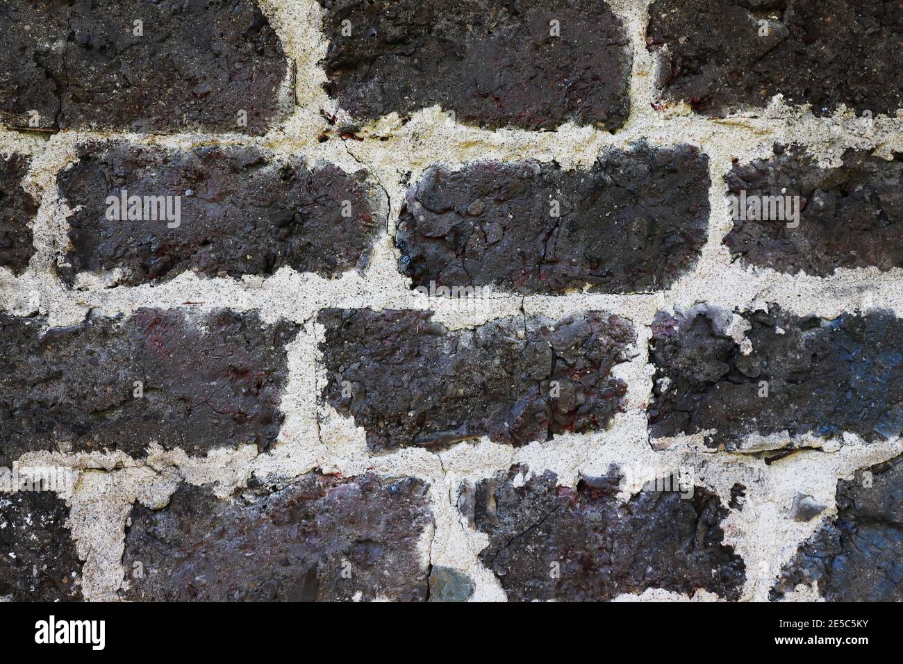 Old brickwork wall of dark bricks. Stock Photo