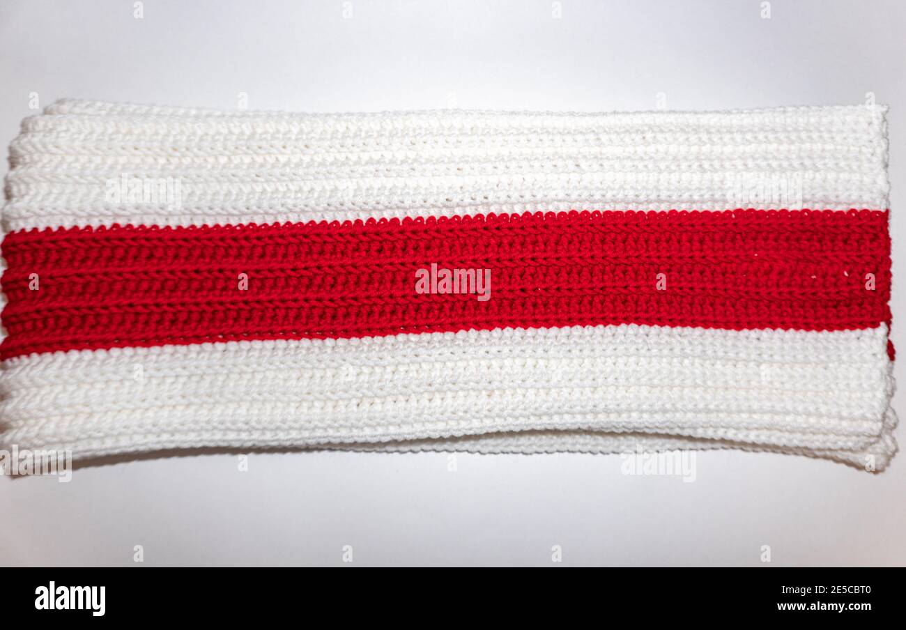 Knitted scarf white red white lies on the table Stock Photo