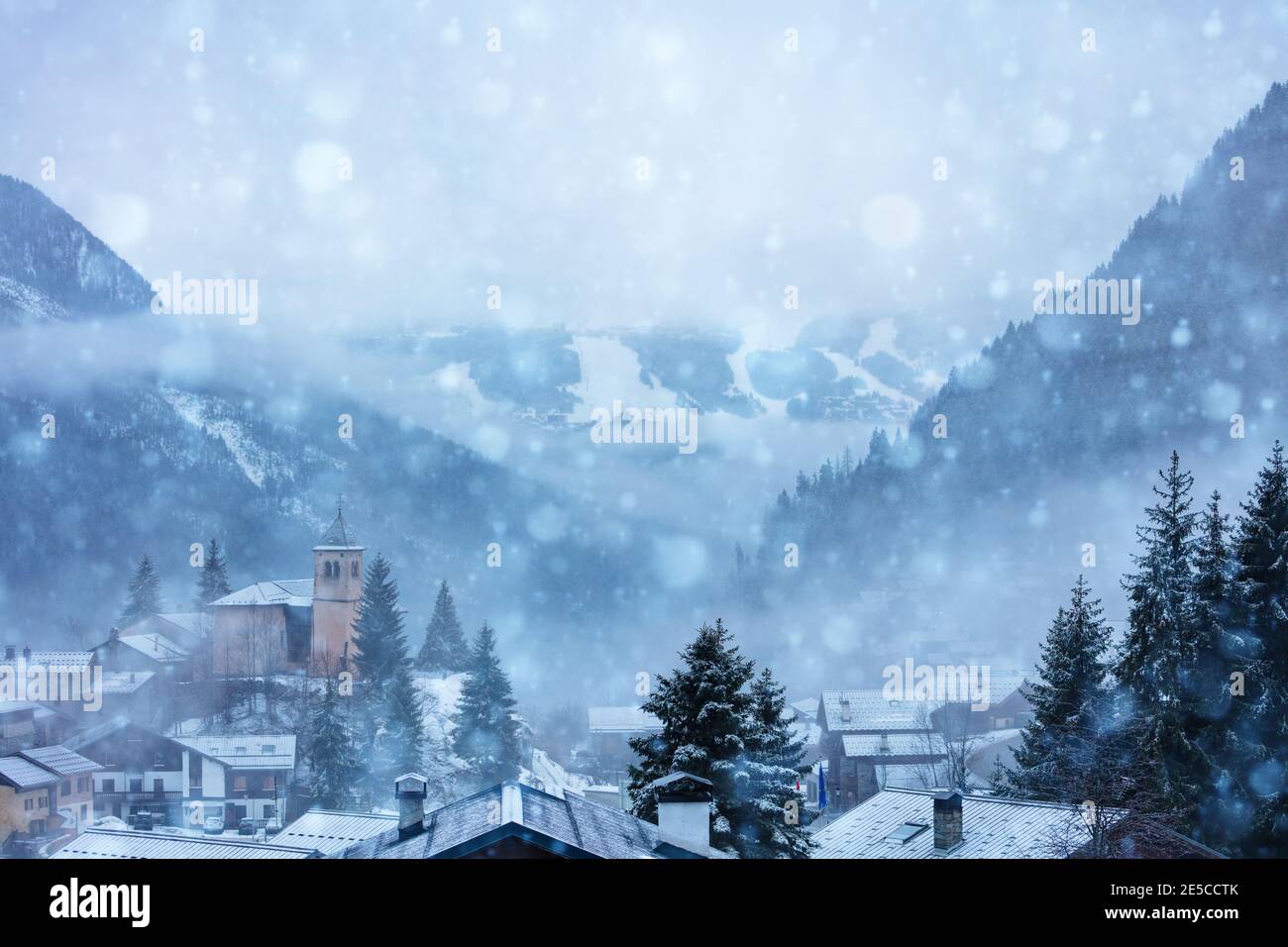 Champagny-en-Vanoise village with church and view on Courchevel during heavy snowfall at winter Stock Photo