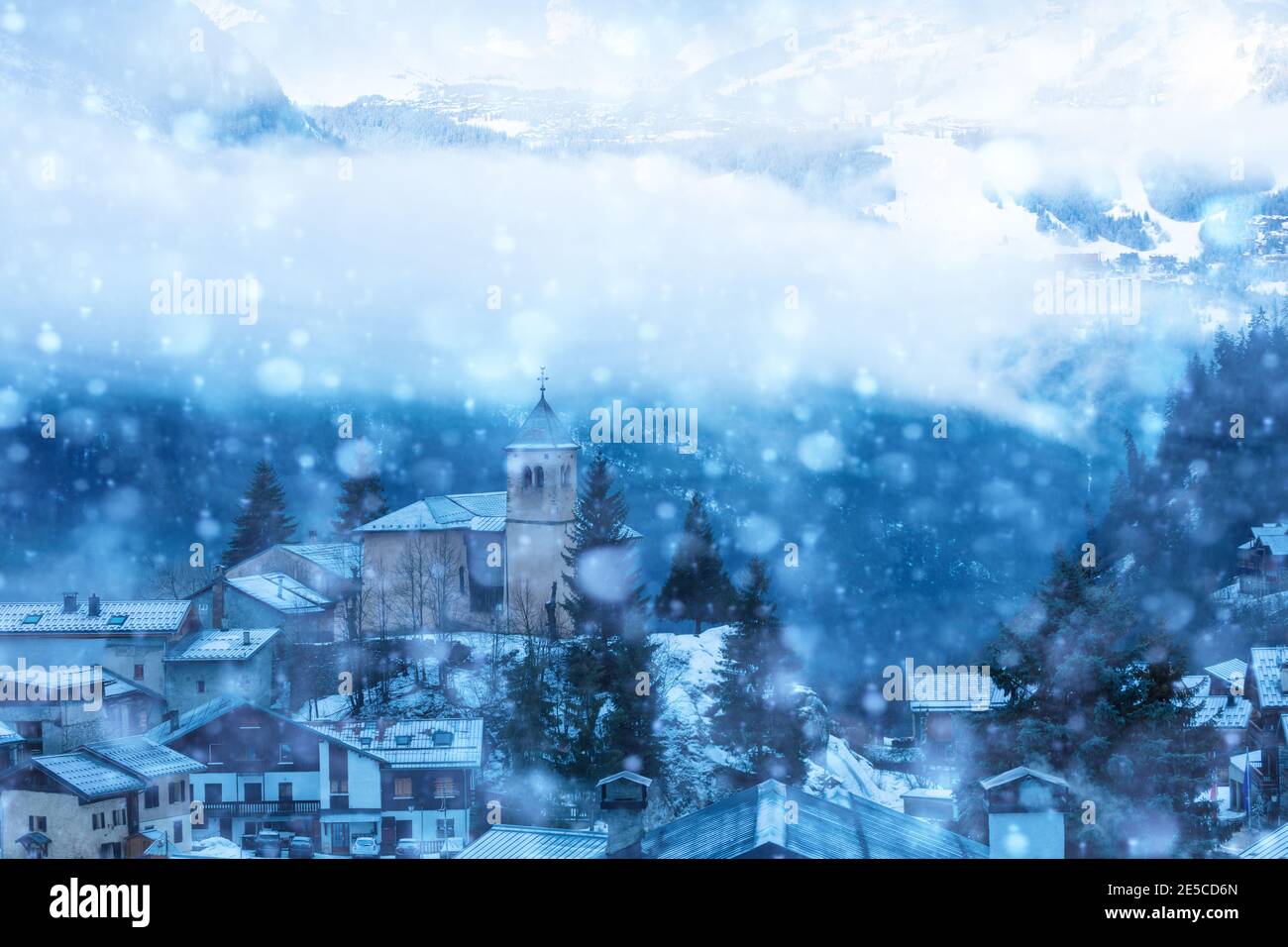 View of church in Champagny-en-Vanoise village in France during heavy snowfall at winter Stock Photo